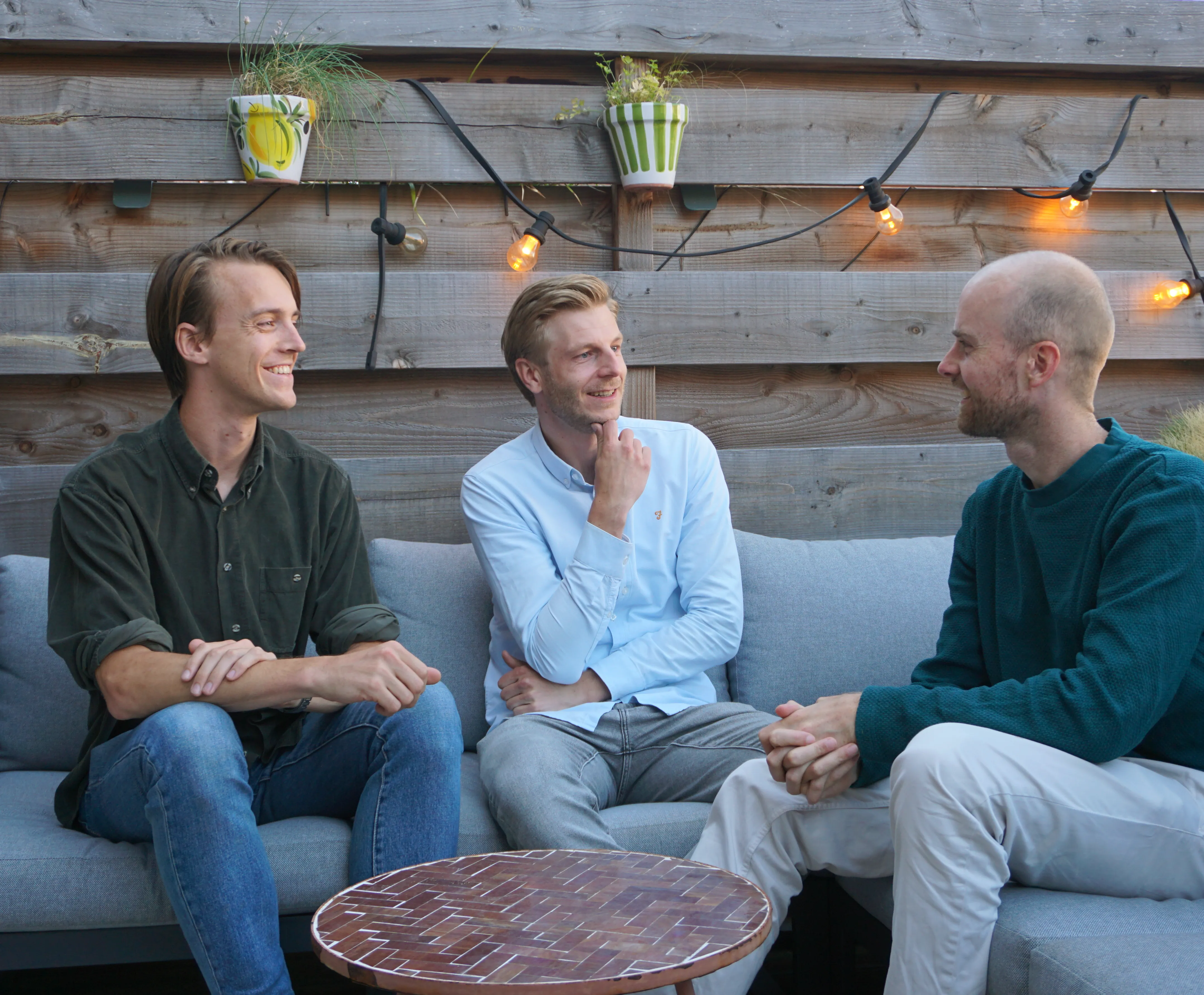 The Go be Smart team — Keje, Charlie, and Age — on a rooftop couch